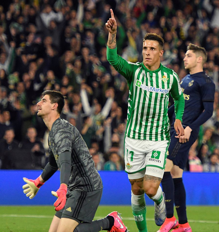 El delantero del Real Betis Cristian Tello (d) celebra ante el guardameta belga del Real Madrid Thibaut Courtois el segundo gol del equipo sevillano