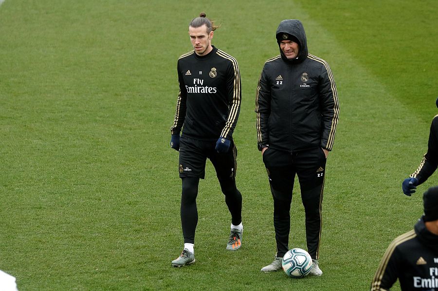 El entrenador francés del Real Madrid, Zinedine Zidane (d) junto al jugador galés Gareth Bale (i), en la previa del partido de la decimoctava jornada de LaLiga