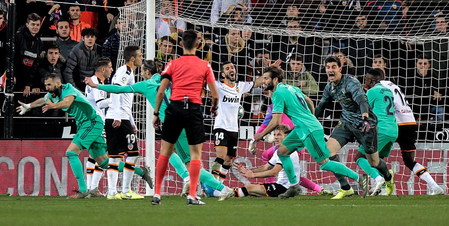 El delantero del Real Madrid Karim Benzema (i) celebra su gol, conseguido en el último minuto del partido ante el Valencia CF, durante el partido correspondiente a la 17ª jornada de LaLiga