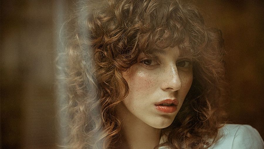 Melena Curly con gran flequillo. Un look muy ochentero que se lleva mucho y que favorece a rostros redondeados o cuadrangulares