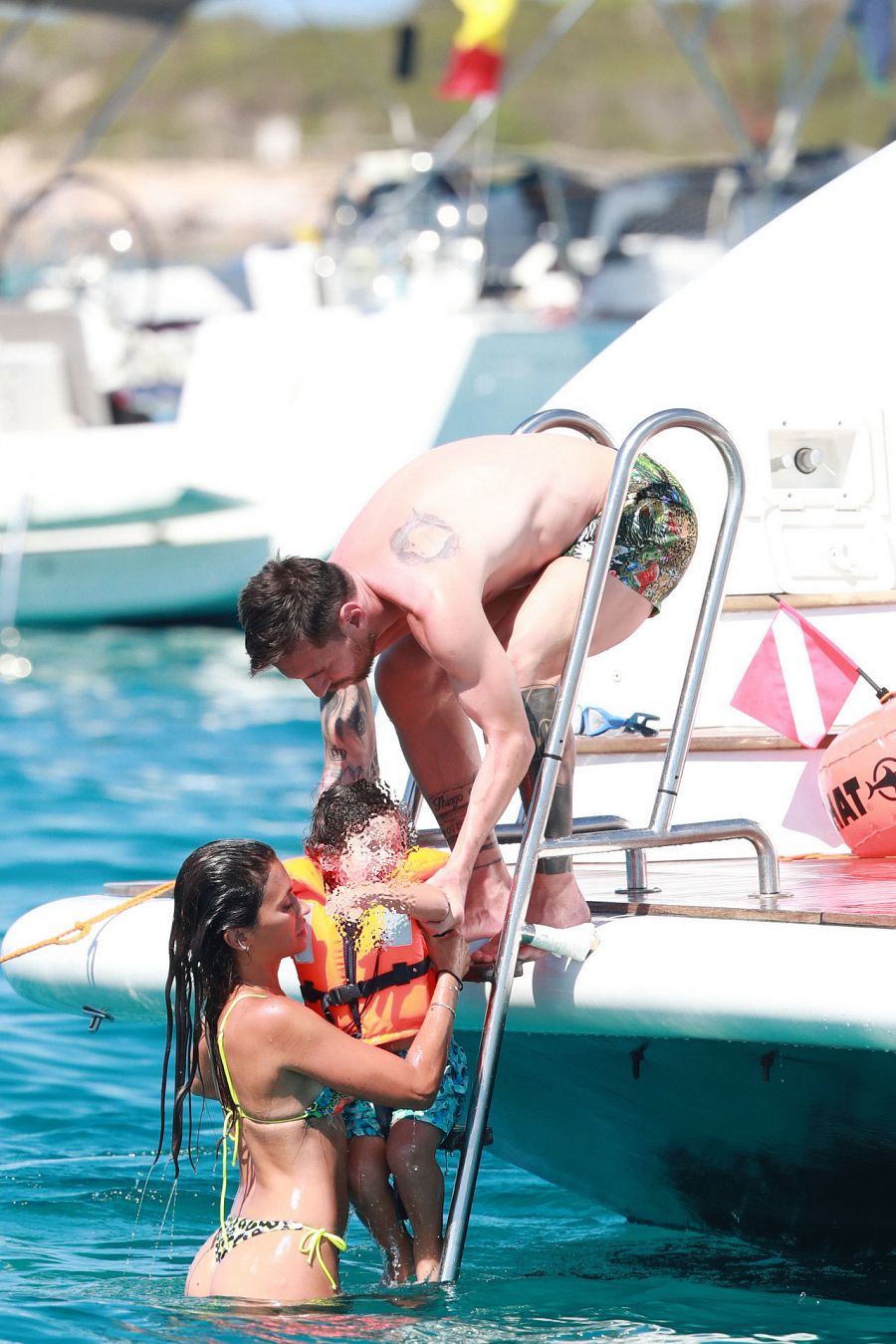 Antonella Roccuzzo y Leo Messi ayudan a salir a uno de sus hijos del agua durante unas vacaciones en Ibiza en el verano de 2020