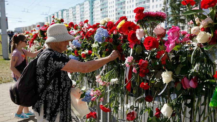 Personas depositan flores en el lugar donde murió un manifestante bielorruso en las protestas de la noche anterior en Minsk.
