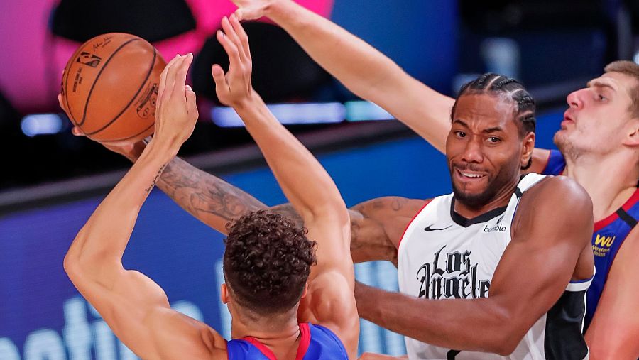 El alero de LA Clippers, Kawhi Leonard en acción frente a Nikola Jokic y Michael Porter
