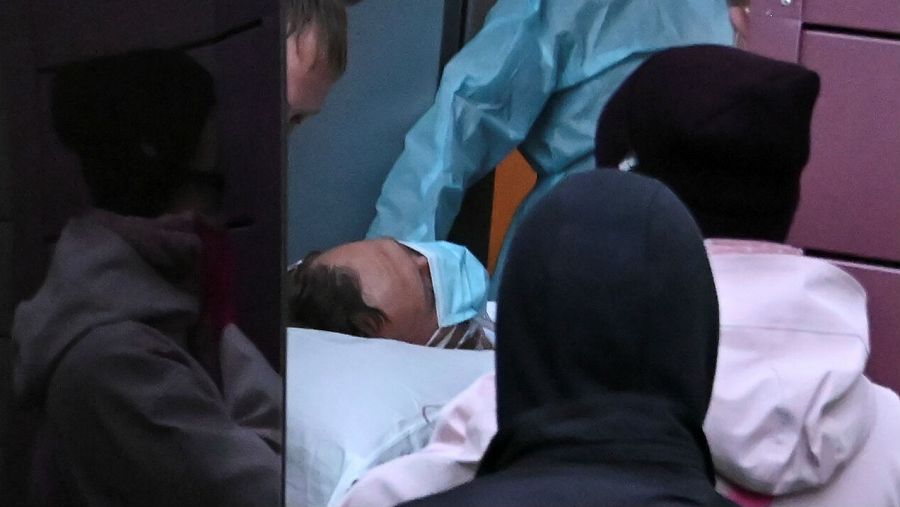 Especialistas médicos llevan al líder de la oposición rusa Alexei Navalny en una camilla a una ambulancia en su camino a un aeropuerto antes de su evacuación médica a Alemania en Omsk, Rusia.