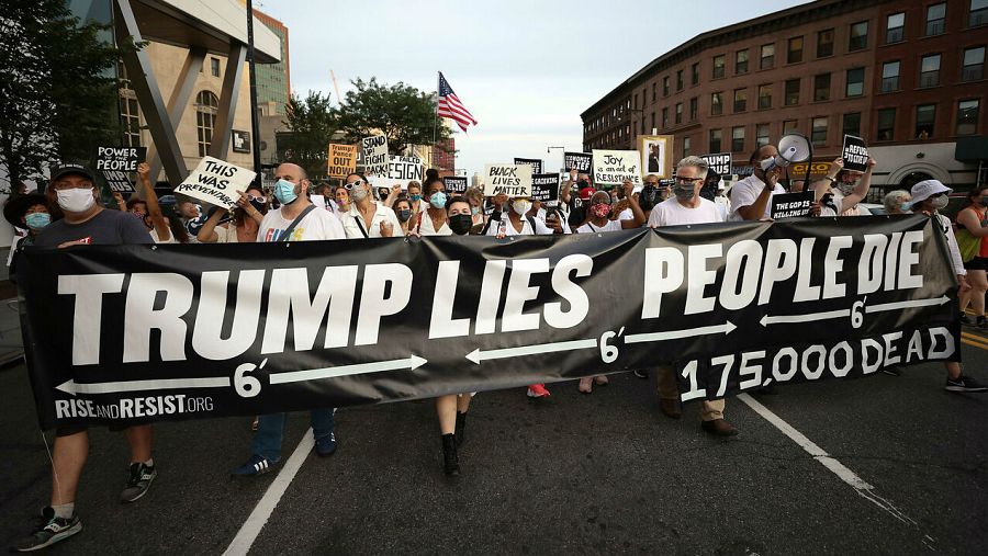 Las personas se reúnen para una vigilia y una 'Marcha por los Muertos' por las víctimas de la pandemia de coronavirus, en Brooklyn, Nueva York, EE. UU. con una pancarta que dice 