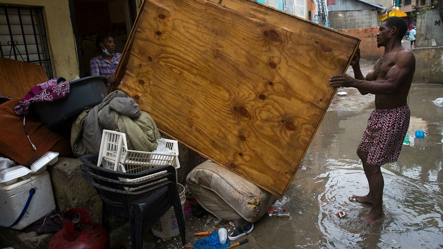 Una pareja saca algunas de sus pertenencias a la calle para que se sequen después de que su hogar se inundara debido a las intensas lluvias en Santo Domingo (República Dominicana).