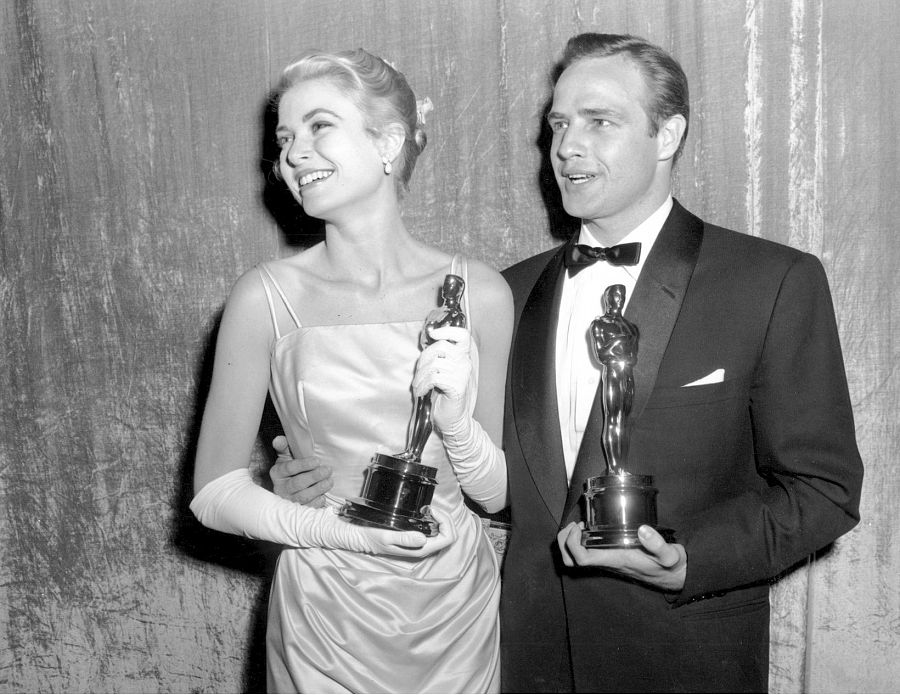 Grace Kelly y Marlon Brando posan con sus estatuillas en la 27ª edición de los pemios Oscar