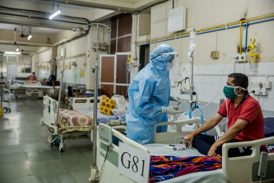 El Dr. Ilham Ashraf examina a un paciente en la sala de hospitalización con un equipo de oxígeno nasal de alto flujo del hospital.