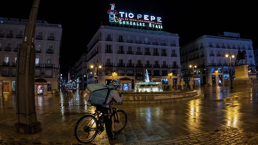Un repartidora de comida a domicilio en la Puerta del Sol, durante la primera jornada de toque de queda en Madrid.