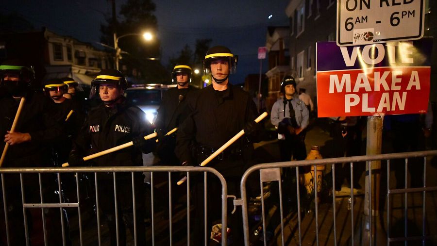 La policía con equipo táctico forma una línea al lado de un 