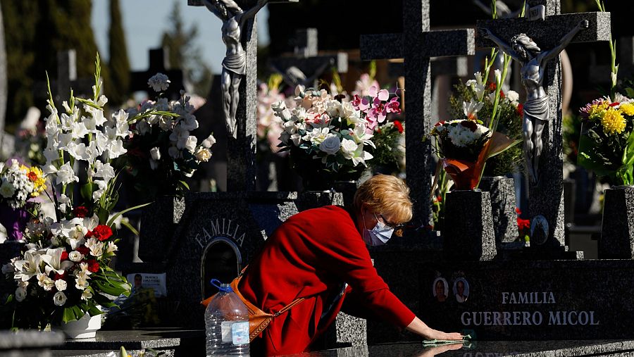 Una mujer limpia una tumba del Cementerio Cristo de la Salud Espinardo en Murcia (España).