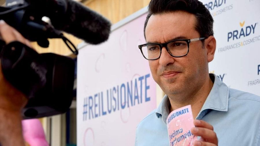 El director de visión de la administración, Miguel Ángel Zapata, sostiene el sobre del décimo de Lotería de Navidad perfumado