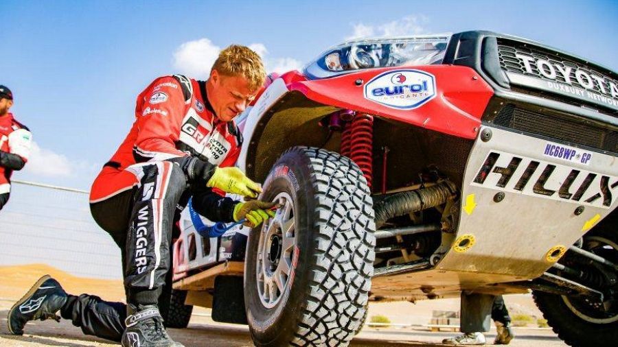 Imagen de un participante en el Rally Dakar reparando su vehículo.