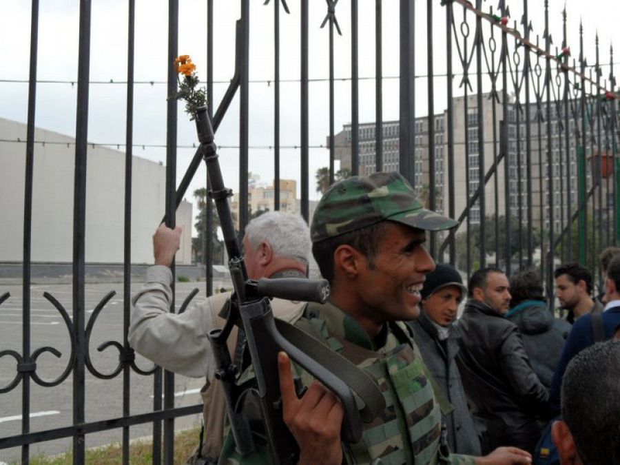 Un militar tunecino con una flor en su arma.