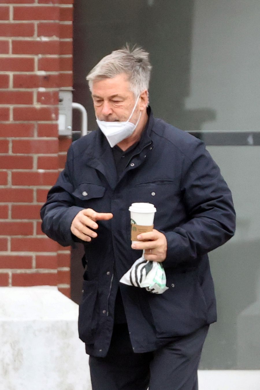 Alec Baldwin saliendo de una cafetería solo
