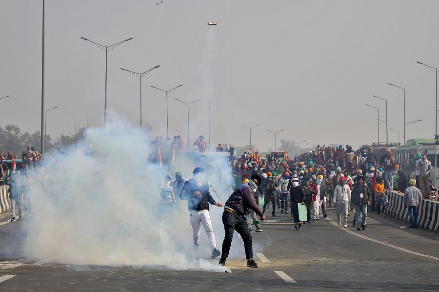 Un hombre lanza gas lacrimógeno a la Policía durante una manifestación de agricultores en India