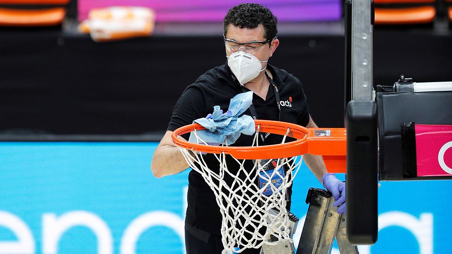 Un miembro de la organización desinfecta un aro en la burbuja de Valencia.