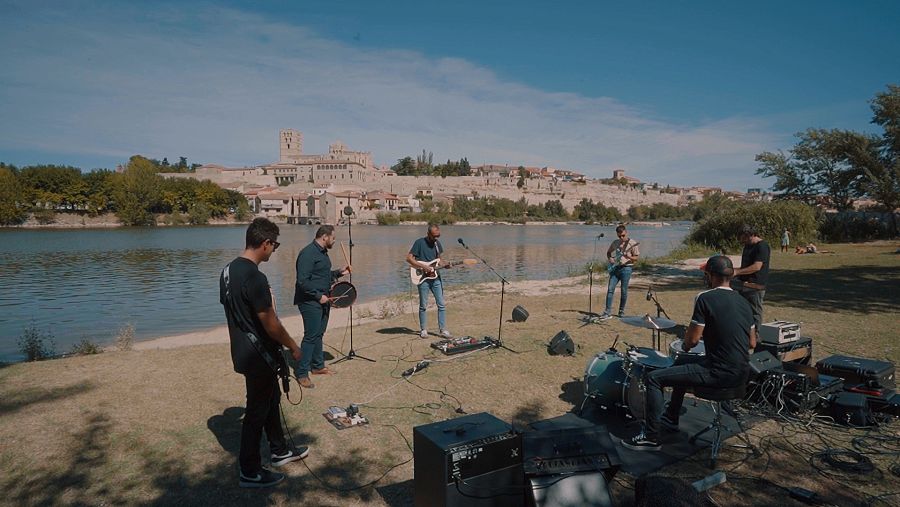 Músicos tocando con la ciudad de Zamora de fondo