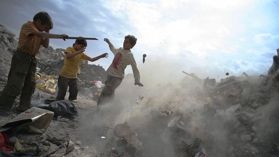 Un grupo de jóvenes recogen metal y plásticos entre los escombros en Alepo (Siria)