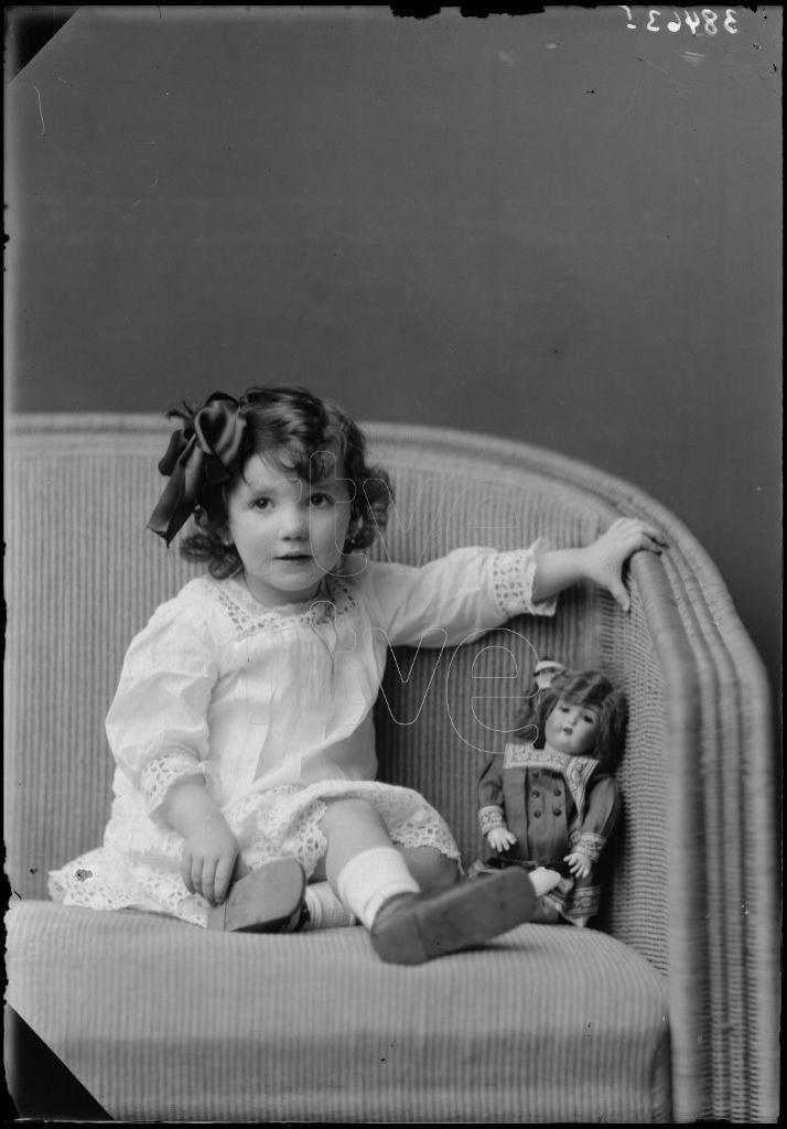 NI&Ntilde;A DE CORTA EDAD SENTADA CON UNA MU&Ntilde;ECA