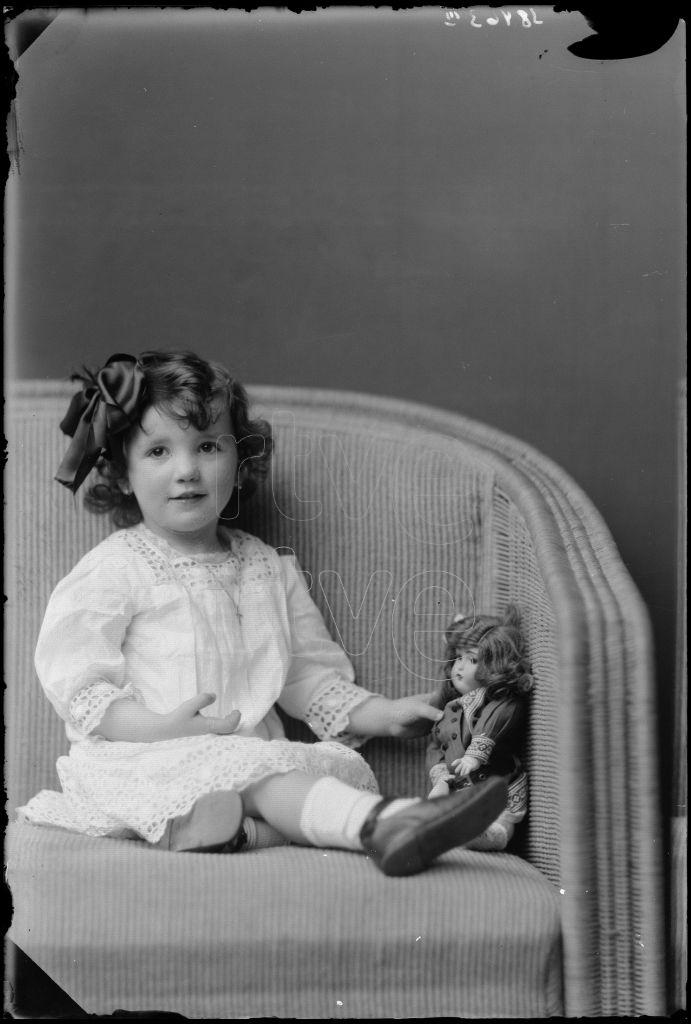 NI&Ntilde;A DE CORTA EDAD SENTADA CON UNA MU&Ntilde;ECA