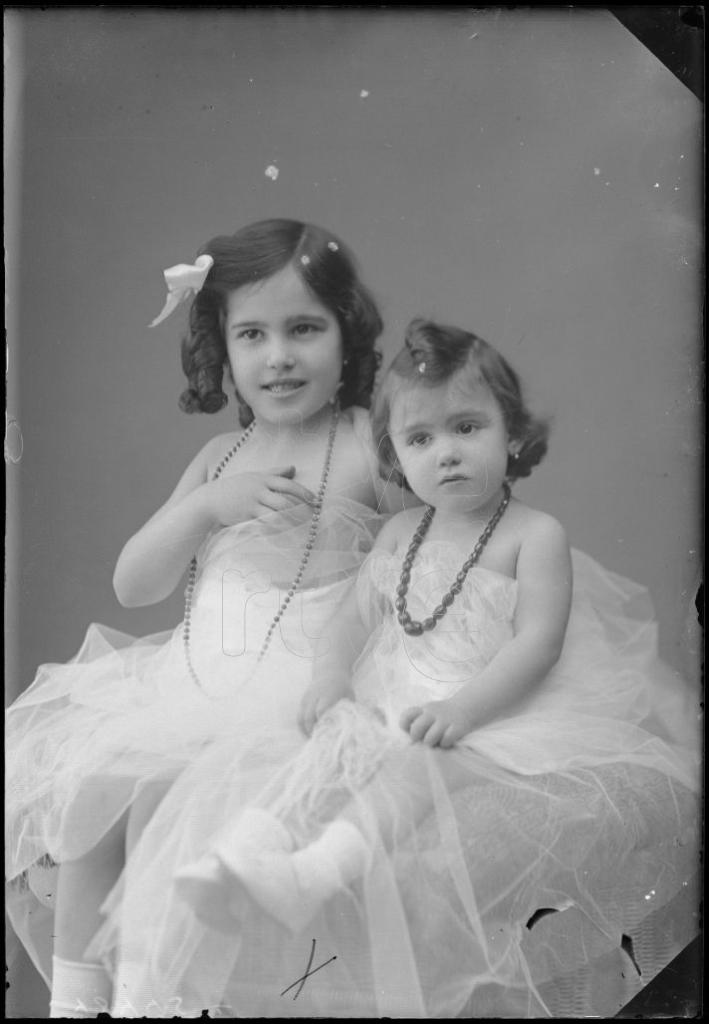 DOS NI&Ntilde;AS DE CORTA EDAD SENTADAS