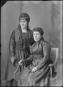 DOS MUJERES, UNA DE ELLAS SENTADA