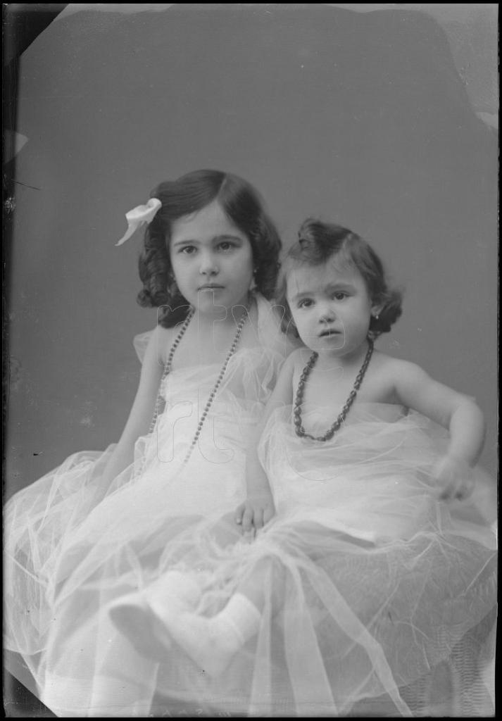 DOS NI&Ntilde;AS DE CORTA EDAD SENTADAS