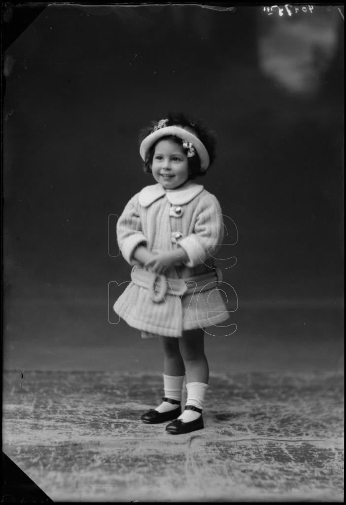 NIÑA DE CORTA EDAD CON UN ABRIGO Y UN SOMBRERO