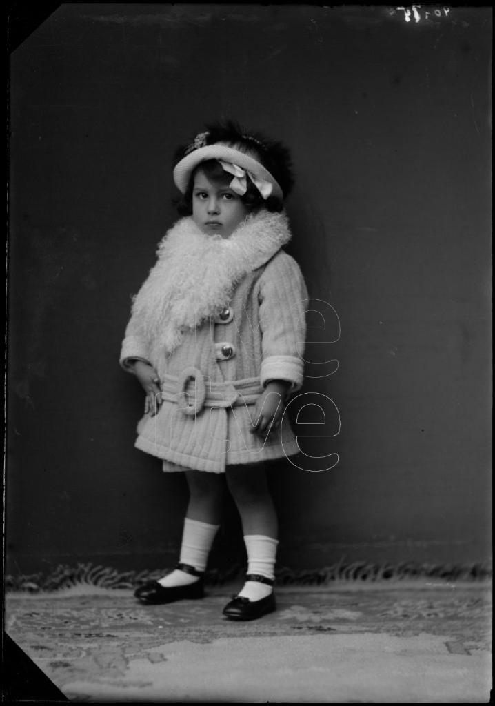 NIÑA DE CORTA EDAD CON UN ABRIGO, UN SOMBRERO Y UNA ESTOLA D