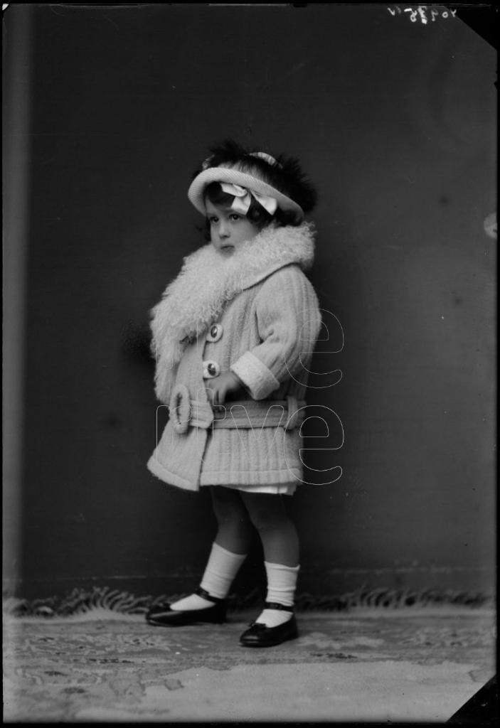 NIÑA DE CORTA EDAD CON UN ABRIGO, UN SOMBRERO Y UNA ESTOLA D