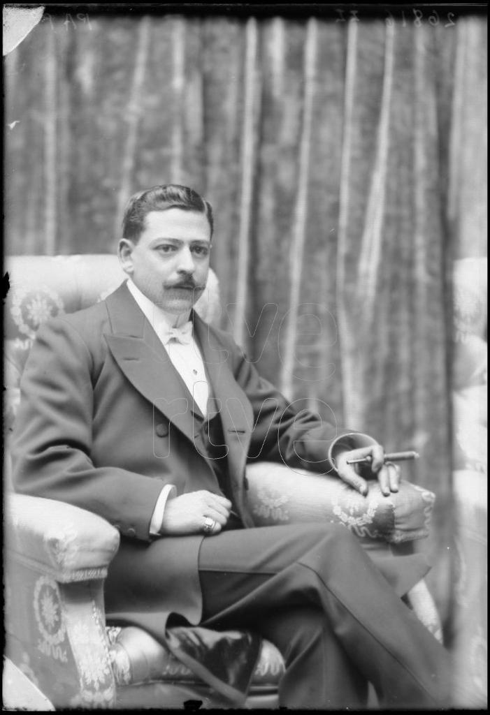 SEÑOR CON UN CIGARRILLO EN LA MANO, SENTADO