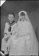 NIÑO Y NIÑA VESTIDOS DE PRIMERA COMUNION, SENTADOS