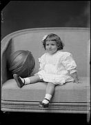 NI&Ntilde;A DE CORTA EDAD SENTADA JUNTO A UN BALON