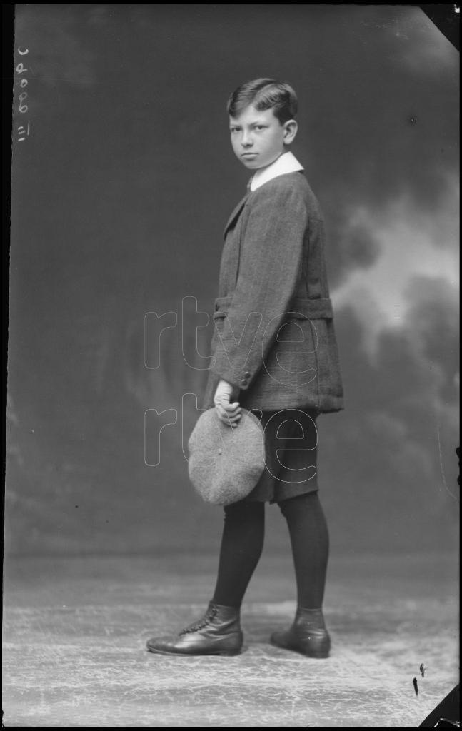 NIÑO CON LA GORRA EN UNA MANO