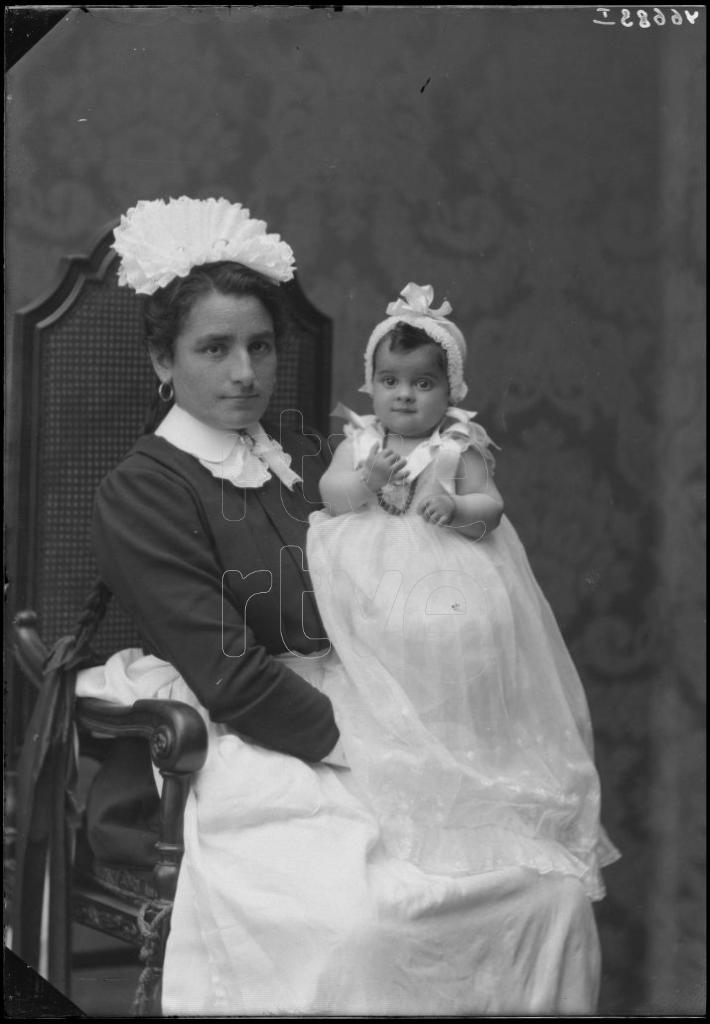 AMA DE CRIA SENTADA CON UN BEBE EN BRAZOS