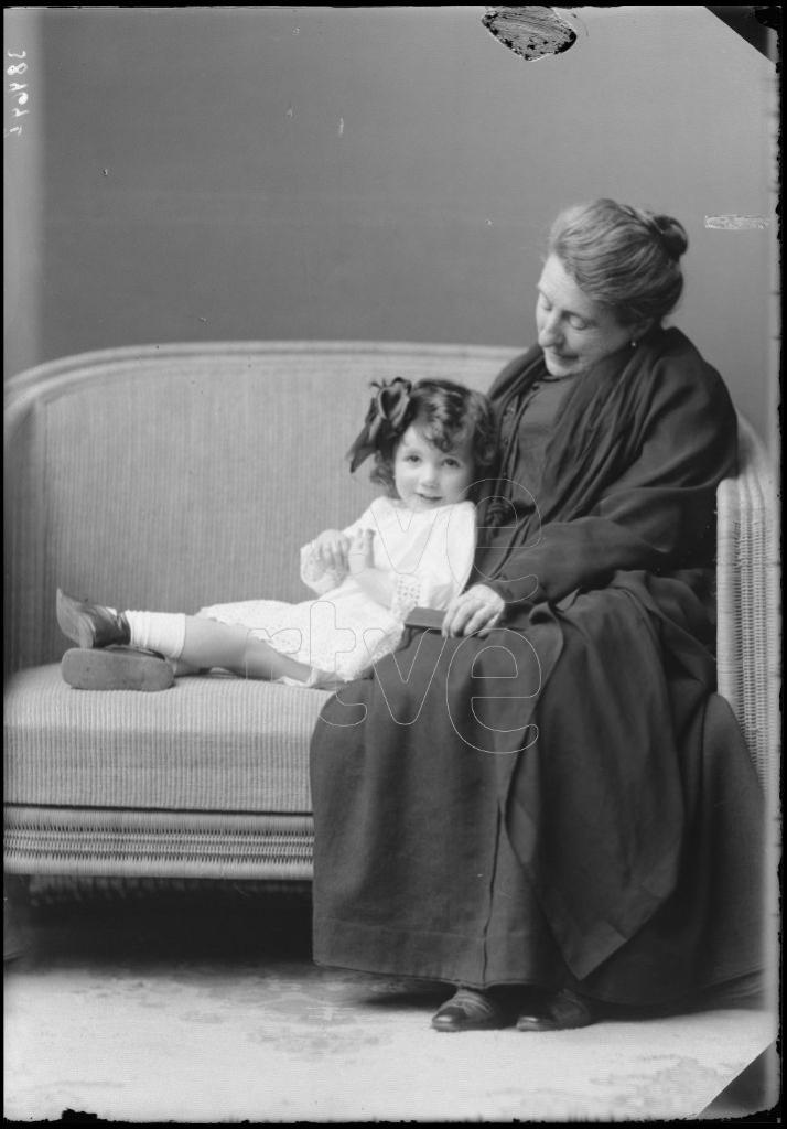 ANCIANA SENTADA CON UNA NIÑA DE CORTA EDAD