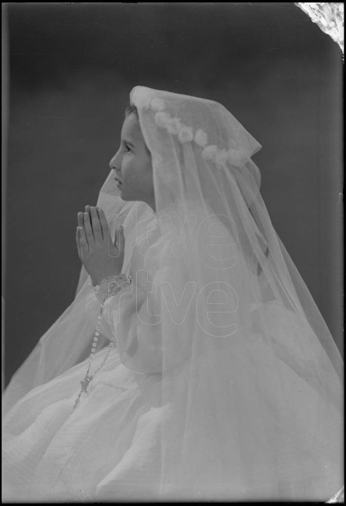 NI&Ntilde;A VESTIDA DE PRIMERA COMUNION, SENTADA DE PERFIL CON LA M