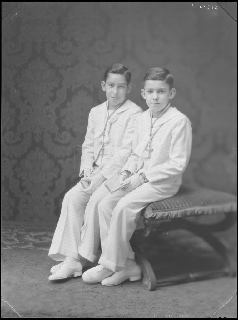 DOS NIÑOS VESTIDOS DE PRIMERA COMUNION, SENTADOS