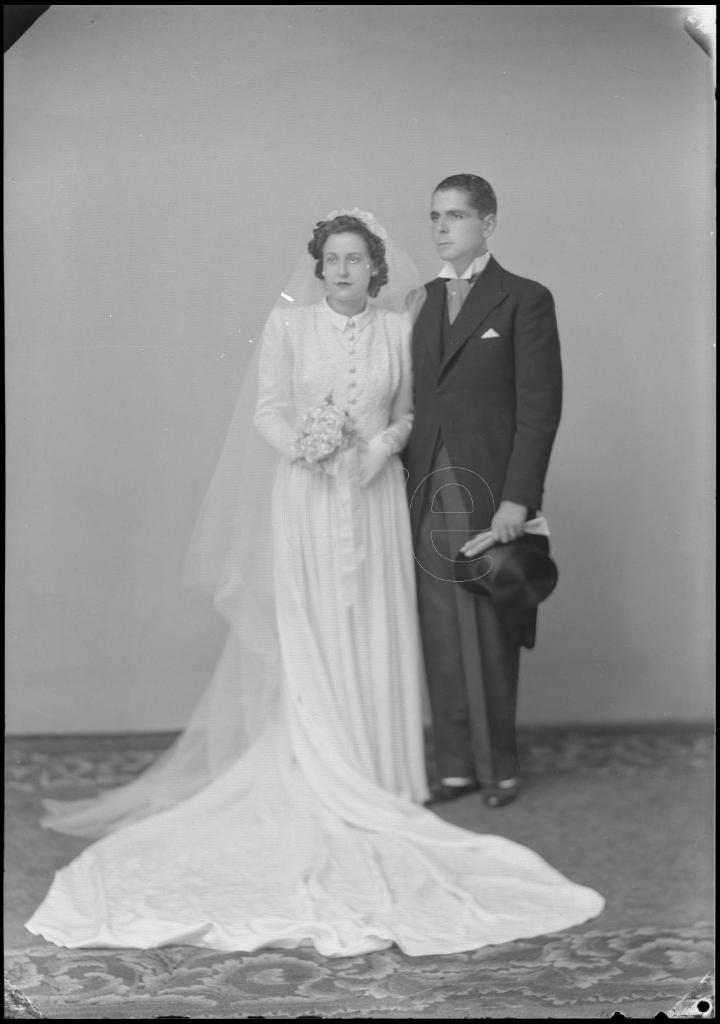 NOVIA CON UN VELO LARGO CON UN TOCADO, EL VESTIDO CON COLA Y