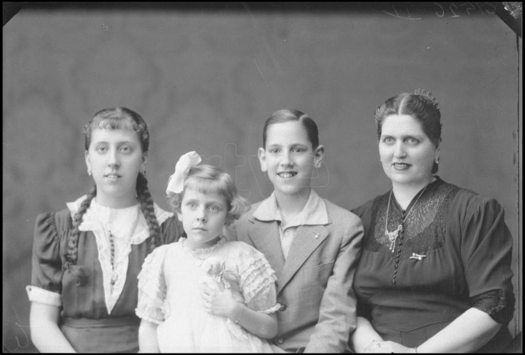 MUJER SENTADA CON DOS NIÑAS Y UN NIÑO