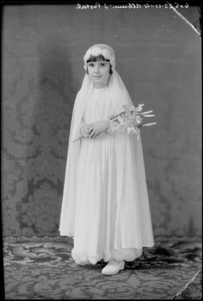 NIÑA VESTIDA DE PRIMERA COMUNION CON UN RAMO