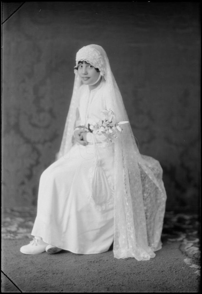 NI&Ntilde;A VESTIDA DE PRIMERA COMUNION CON UN RAMO, SENTADA