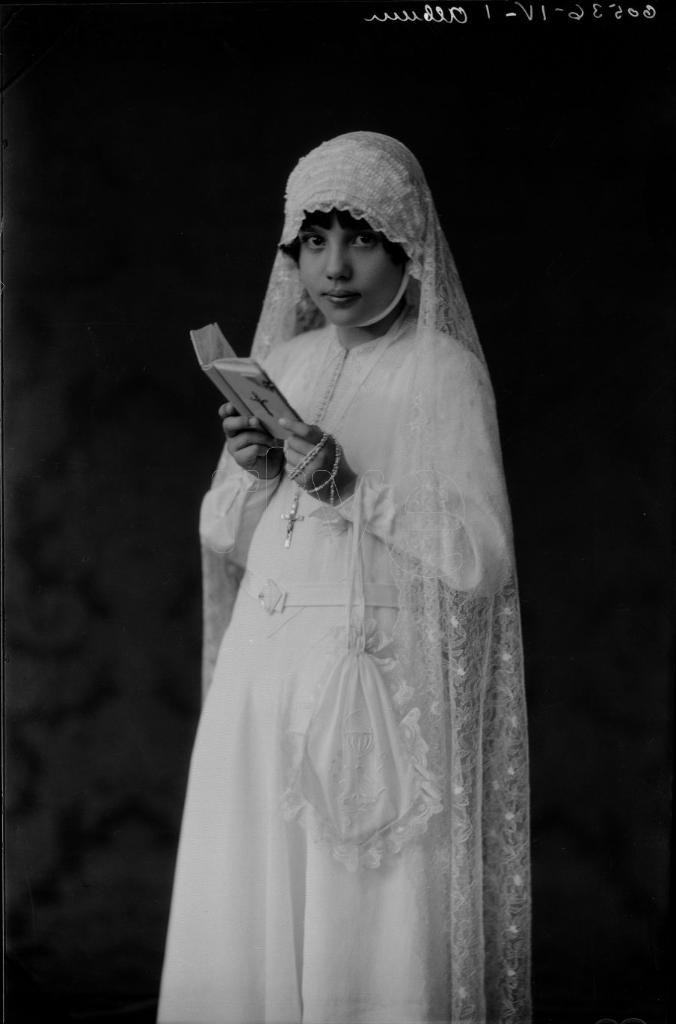 NI&Ntilde;A VESTIDA DE PRIMERA COMUNION CON EL MISAL ABIERTO EN LAS