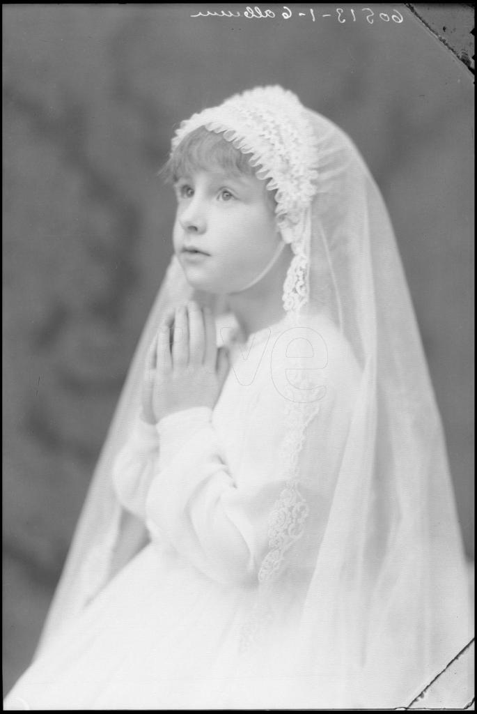 NIÑA VESTIDA DE PRIMERA COMUNION CON LAS MANOS JUNTAS EN POS