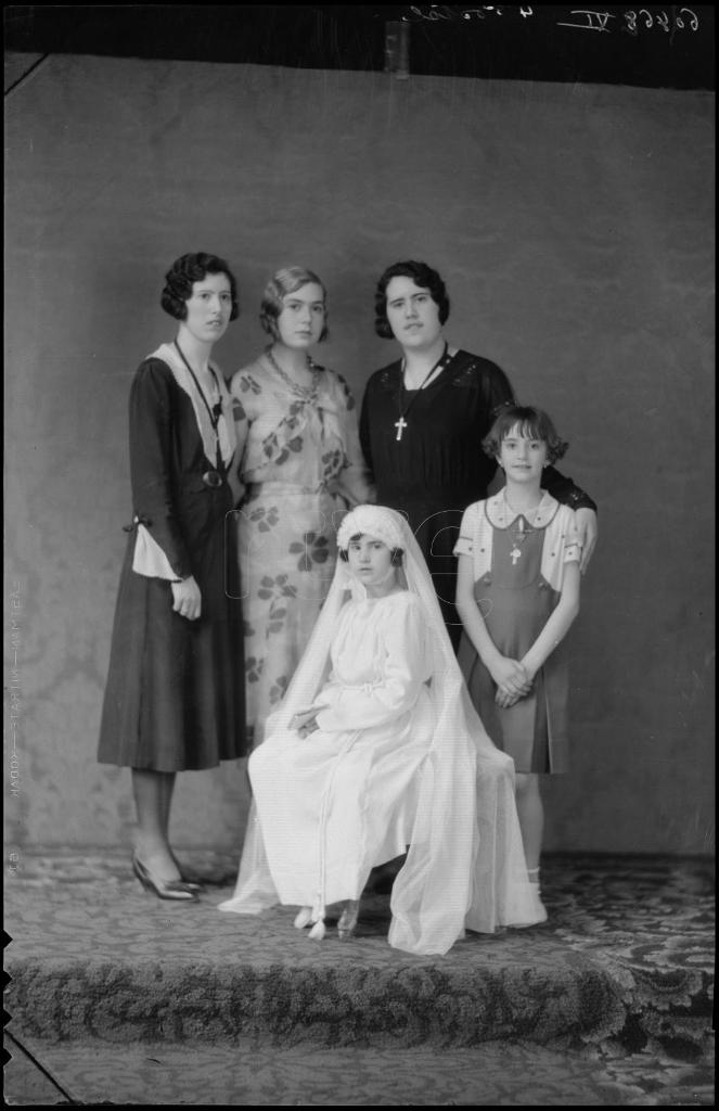 NIÑA VESTIDA DE PRIMERA COMUNION CON TRES MUJERES Y OTRA NIÑ