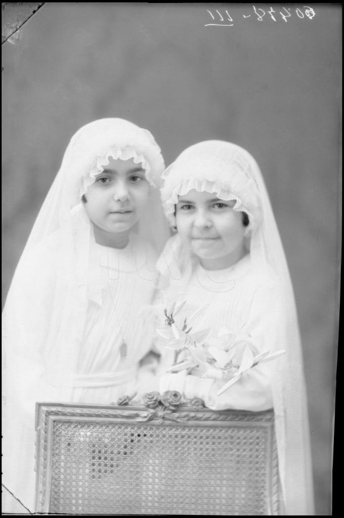 DOS NI&Ntilde;AS VESTIDAS DE PRIMERA COMUNION CON UN RAMO