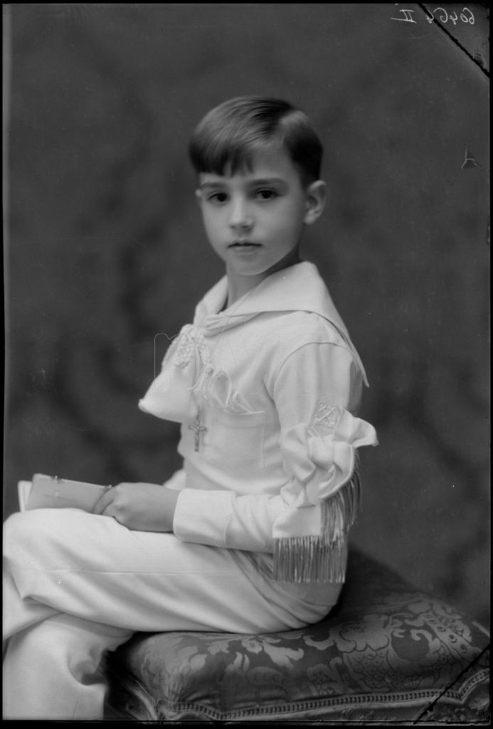 NIÑO VESTIDO DE PRIMERA COMUNION, SENTADO DE PERFIL