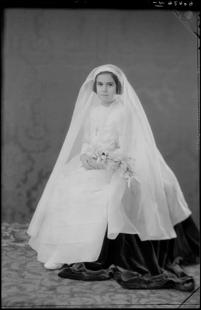 NI&Ntilde;A VESTIDA DE PRIMERA COMUNION CON UN RAMO, SENTADA