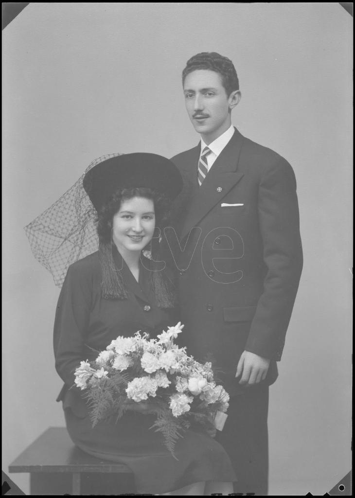 NOVIA VESTIDA DE NEGRO CON UN SOMBRERO Y REJILLA, SENTADA CO